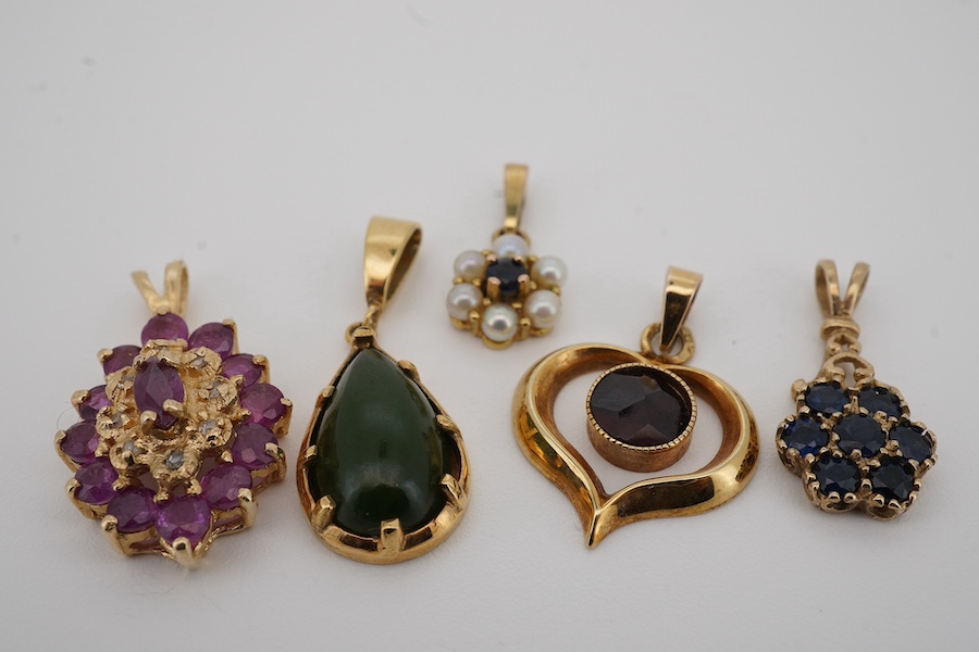 A modern 9ct gold and pear shaped nephrite set pendant, overall 25mm, a similar 9ct gold and garnet set pendant and three other gem set pendants, including 9ct and two unmarked. Condition - fair to good